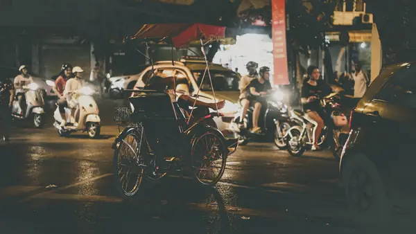Scooters et cyclo-pousse rue Hang Bong, à Hanoi, de nuit